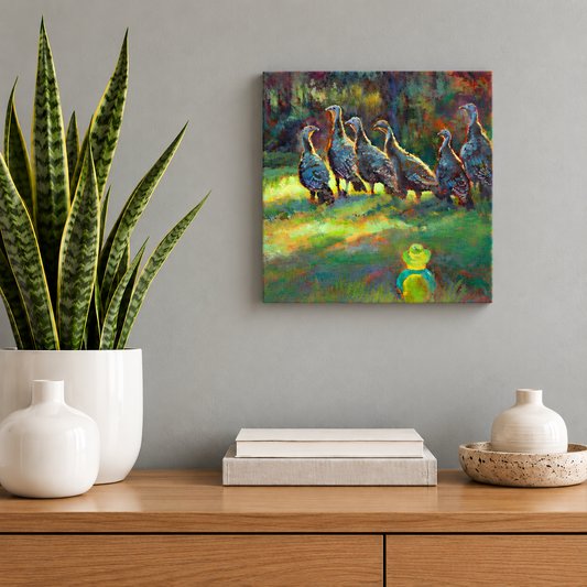 Square wildlife painting by Martina Goulart featuring a group of wild turkeys and a small rubber duck in a colorful woodland scene, displayed above a wooden cabinet with a snake plant and minimalist white ceramic decor.