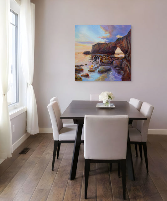 Dining room with table and chairs featuring an original painting of a rock arch, dog, and rubber duck at sunset with orange, blue, and purple skies.