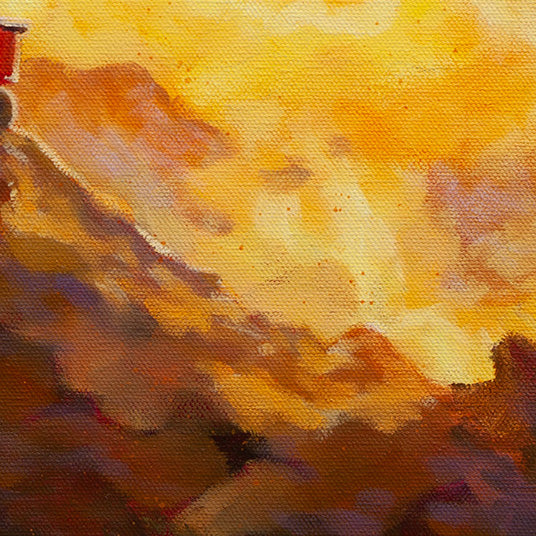 Detail of a sunlit hillside with yellow and orange highlights and deep brown shadows, showing the warm reflection of sunrise along the mountain’s edge.