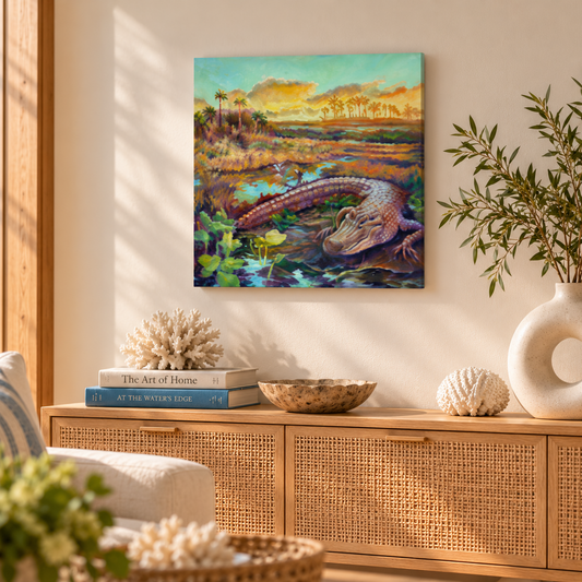 Colorful oil painting of a Florida alligator resting in a vibrant Everglades marsh at sunset, displayed above a natural wood and rattan cabinet in a warm, sunlit coastal living room with neutral decor and a sculptural ceramic vase.