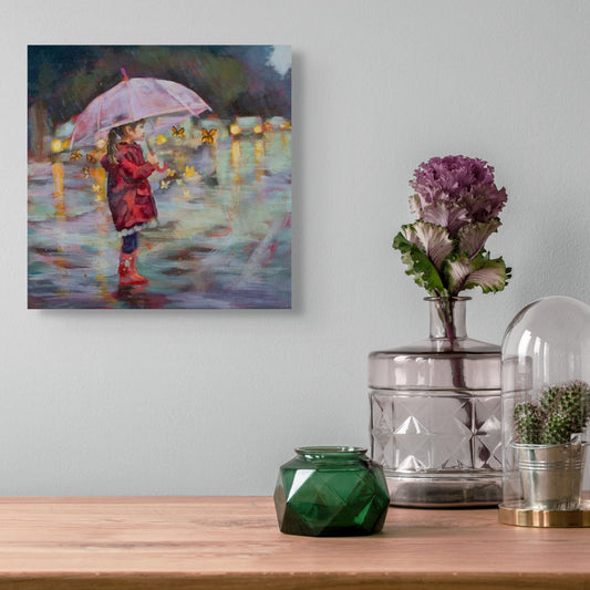 Decorative setup with a painting of a child with an umbrella, vases, and a cactus on a wooden surface.