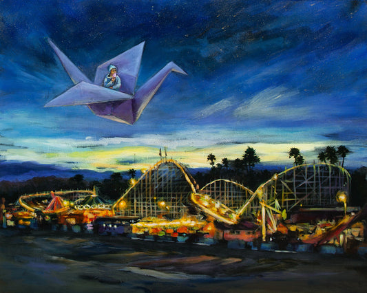 Dreamlike nighttime painting of a glowing seaside amusement park under a deep blue sky, with warm lights illuminating roller coasters below and a child flying overhead in a large purple paper crane, exploring illusion, light, and darkness.