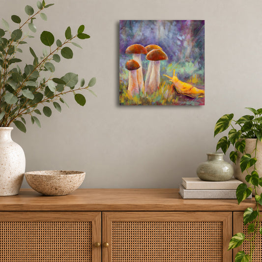 Colorful original oil painting by Martina Goulart featuring four woodland mushrooms and a bright yellow banana slug in a whimsical forest scene, displayed above a wooden cabinet in a modern living room.