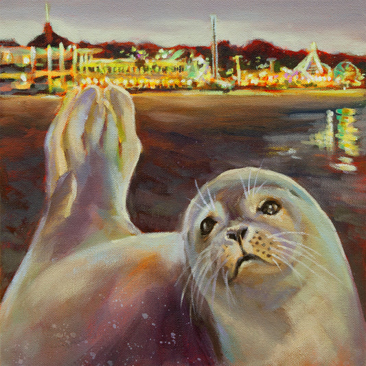 Small oil painting of a young seal lying on the beach at dusk with the glowing Santa Cruz Beach Boardwalk and its colorful lights shimmering in the background.