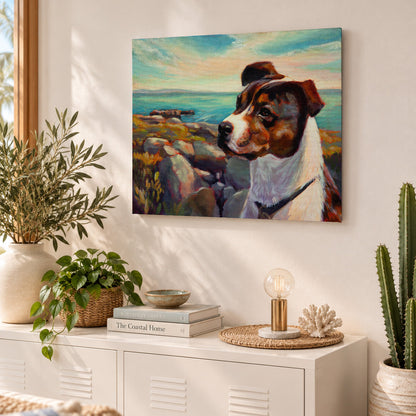 Colorful oil painting of a brown-and-white dog overlooking a rocky ocean coastline, displayed above a white cabinet in a sunlit coastal-style living room with natural textures, greenery, and warm neutral decor.