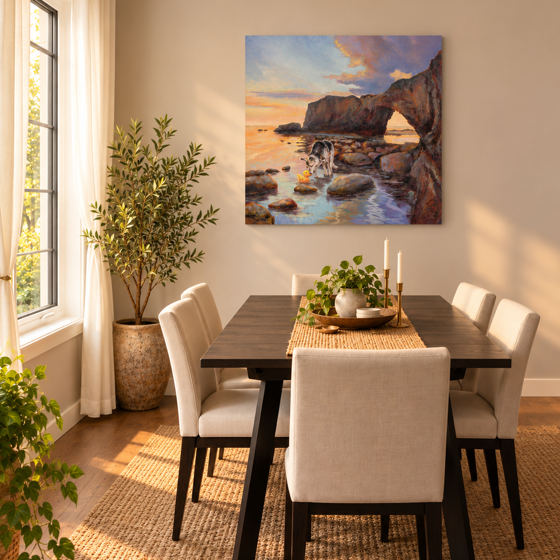 Colorful coastal oil painting by Martina Goulart featuring a dog and yellow rubber duck exploring tide pools near a rocky ocean arch, displayed in a cozy, sunlit dining room with warm neutral decor and green plants.