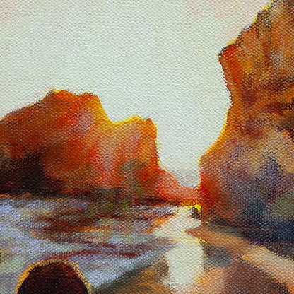 Detail of glowing sunset light between coastal rock formations along the shoreline.