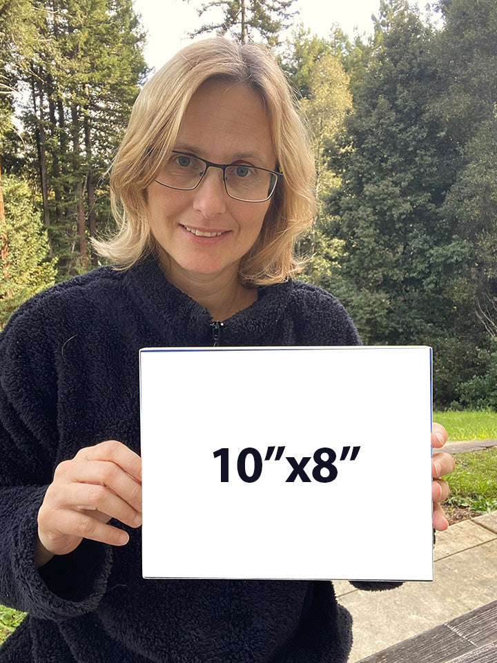 Artist Martina Goulart holding an example of an 8x10 fine art print mounted on cradle wood panel, showing scale and ready-to-hang format