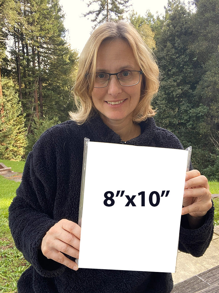 Artist Martina Goulart holding an example of an 8x10 fine art print mounted on cradle wood panel, showing scale and ready-to-hang format