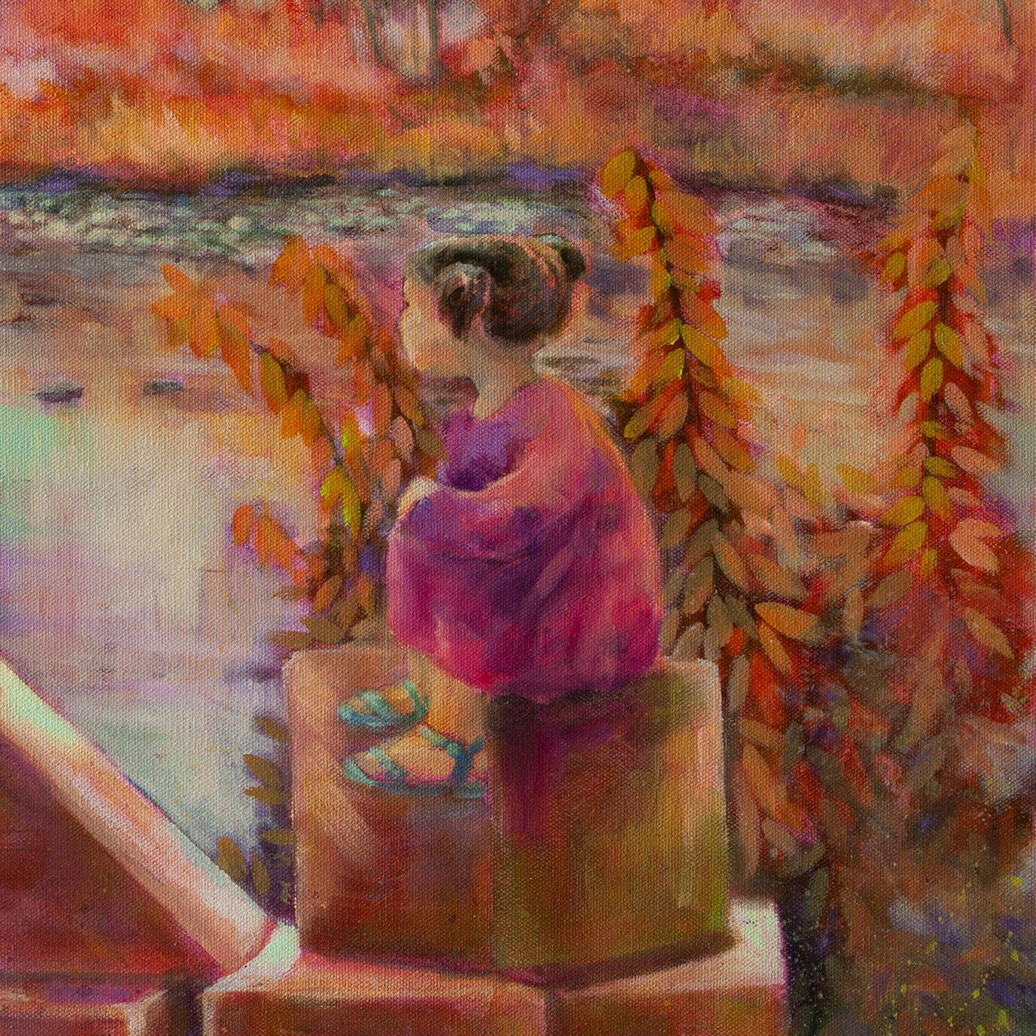 Close-up of girl in pink dress with brown hair sitting on wooden blocks surrounded by tall orange-pink grass near the Merced River.