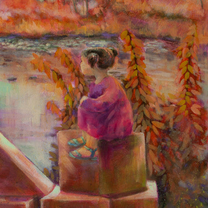 Close-up of girl in pink dress with brown hair sitting on wooden blocks surrounded by tall orange-pink grass near the Merced River.