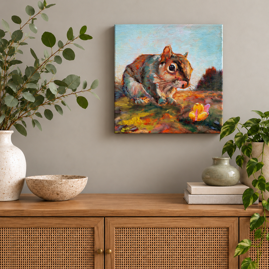 10x10-inch squirrel oil painting from Martina Goulart Studio’s Wild Neighbors series, featuring a curious squirrel and a yellow rubber duck, displayed above a natural wood cabinet with woven doors and botanical decor.