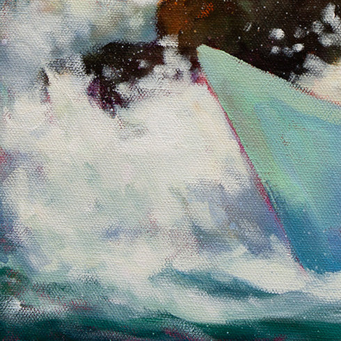 Close-up of a crashing ocean wave hitting the front of a teal paper boat with dark rocks behind it.
