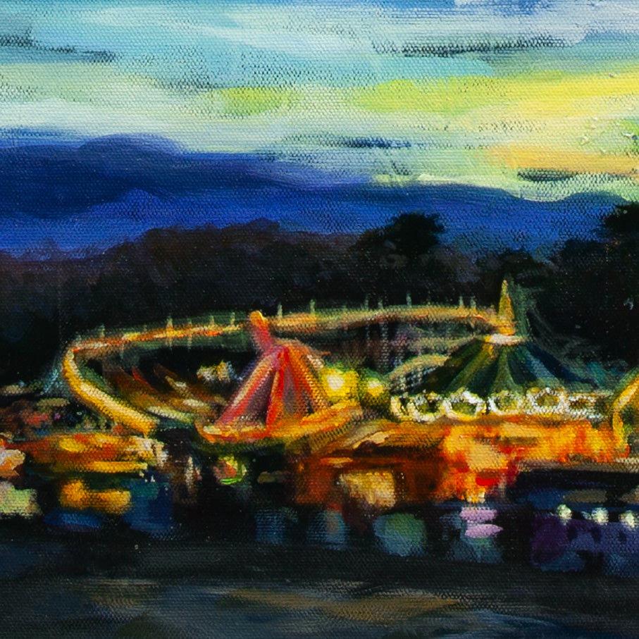 Detail of Santa Cruz Boardwalk rides with glowing yellow, orange, and red lights, dark tree silhouettes, and night sky above.