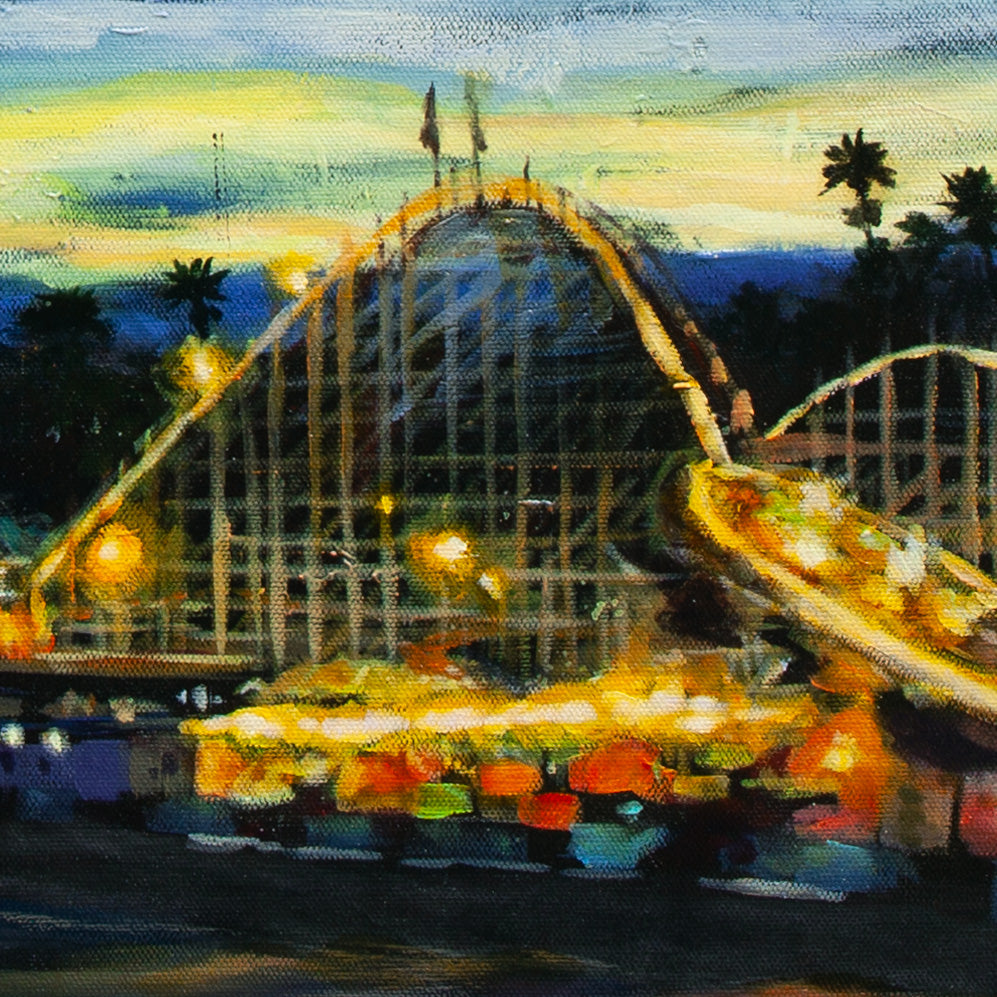 Close-up of the Giant Dipper roller coaster with glowing red, yellow, and orange lights under a golden-yellow sky from Voyage of the Paper Crane.
