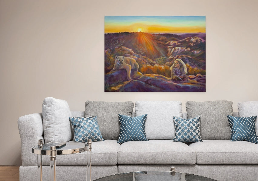 Original painting of a girl and mountain lion at sunset with glowing purples and oranges, hanging above a light gray sofa and glass coffee table