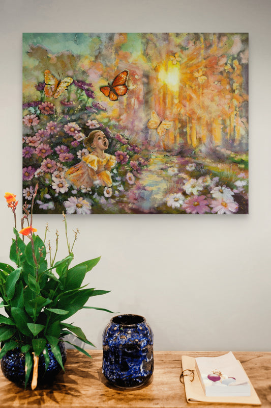 Painting of a girl in a garden with flowers and butterflies on a wall above a table with a vase and plant.