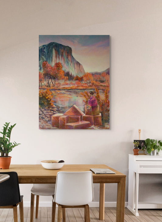 Painting One Day, El Cap. hanging in a dining room with tan table, white chairs, bowl on table, and green houseplants, warm inviting setting.
