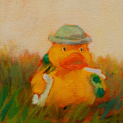 Close-up of a yellow duck with gray hat, white vest, and green binoculars among golden-green grass from Side by Side by Martina Goulart.