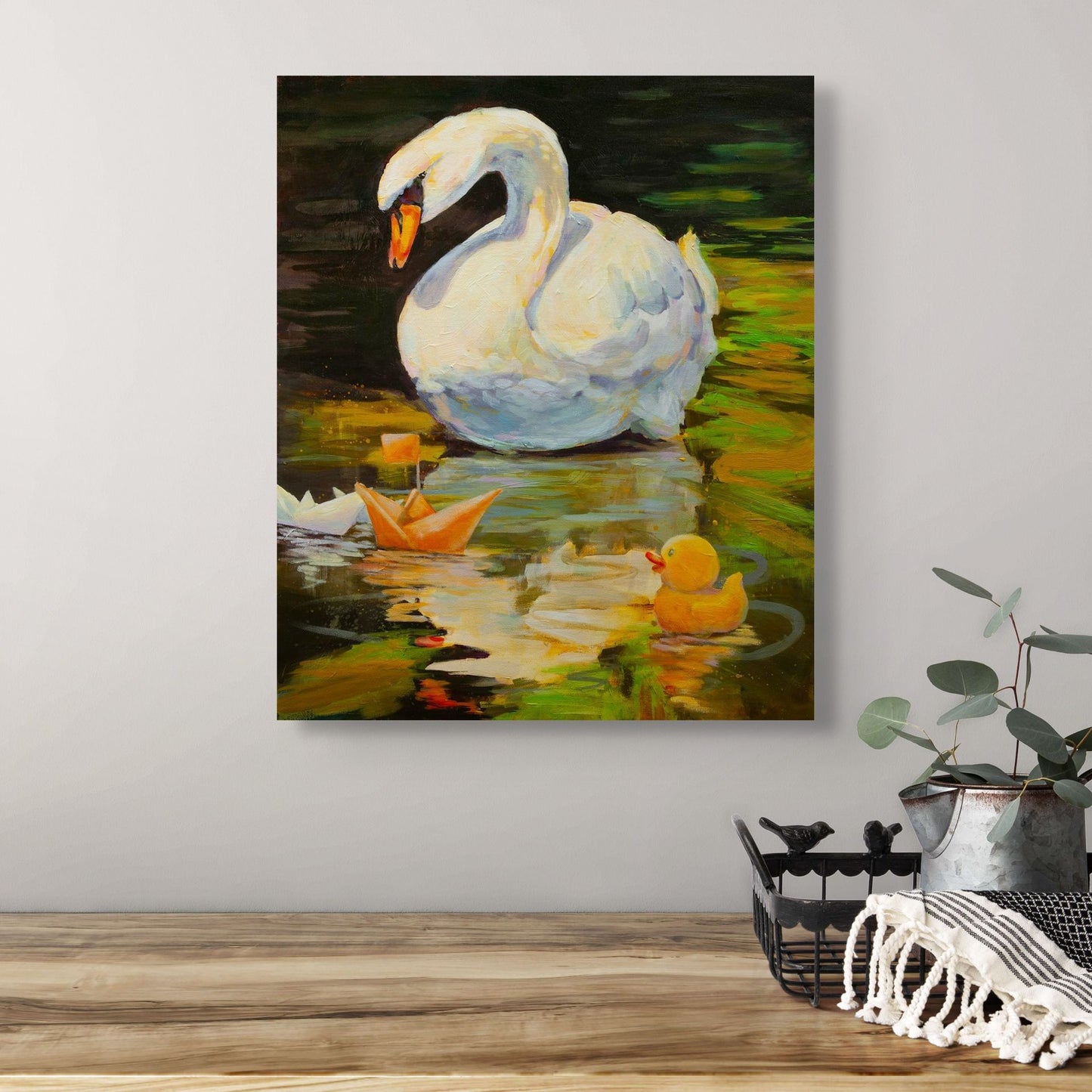 Painting Quiet Company hanging above a natural wood table with a tin houseplant, warm wall tones of green, yellow-green, and orange reflections.”