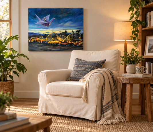Voyage of the Paper Crane displayed on a warm cream wall above a cozy white armchair, surrounded by natural wood, plants, a woven rug and soft lamplight.