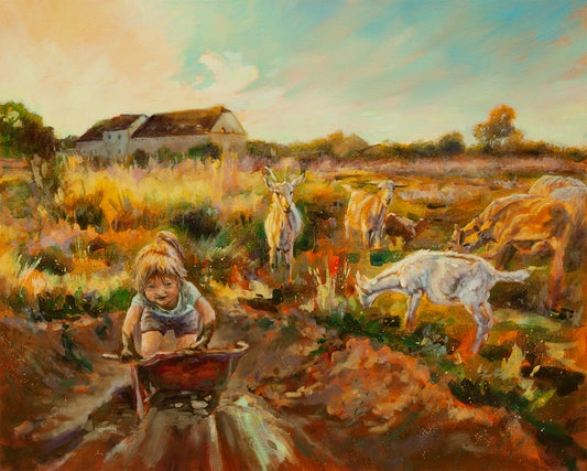 Young girl pushing a wheelbarrow near grazing goats and an old European country building.