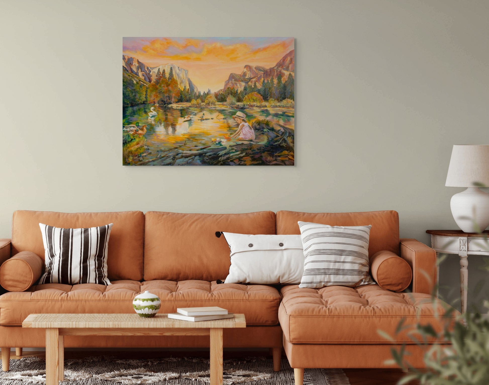 Living room with an orange sofa and coffee table, featuring an original painting of a Yosemite Valley landscape in Yosemite National Park.